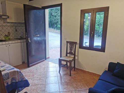 une pièce avec une porte, une chaise et un canapé dans l'établissement Appartamento bilocale sulla Via Francigena a Campagnano di Roma, à Campagnano di Roma