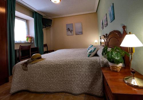 a bedroom with a bed and a table with a lamp at Hotel Rural "La Ruta De Cabrales" in Mestas de Con