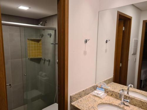 a bathroom with a sink and a shower with a mirror at Apto no Enjoy Olímpia Park Resort in Olímpia
