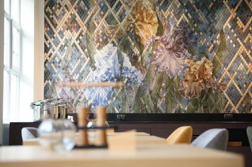 科沃布热格FACTORY RESORT wellness & spa的餐厅里的一幅壁画，配有桌椅