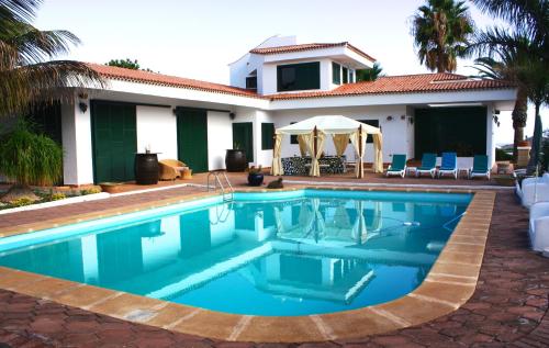 una piscina davanti a una casa di Los Fondos a Costa Del Silencio