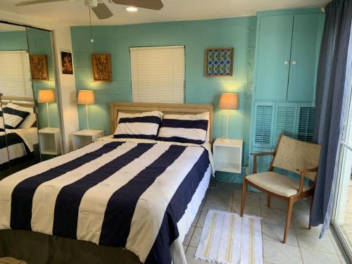 una camera da letto con un letto e una sedia di Bajos - At Casas de la Playa Beachside a Flagler Beach