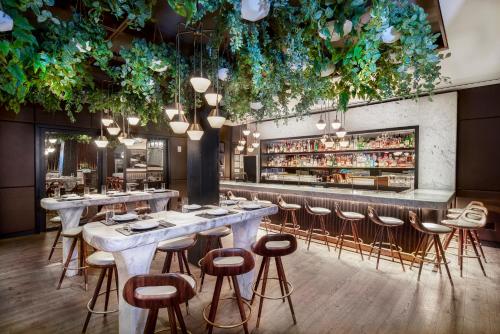 um restaurante com mesas e bancos e um bar em The James New York - NoMad em Nova York