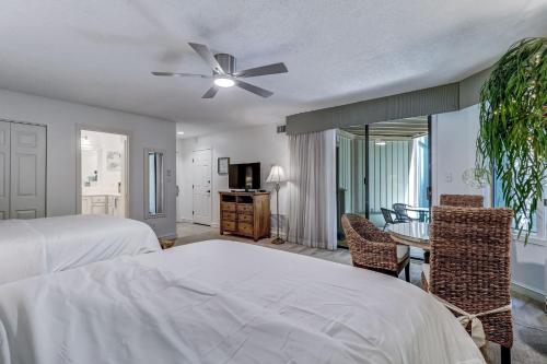 a bedroom with a bed and a table and chairs at Omni Amelia Island Private Room at Courtside Villa-Minutes to Beach and Dining-2358 Boxwood Ln in Fernandina Beach