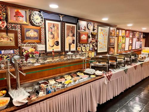 uma linha de buffet com muita comida em exposição em Hotel Bella Italia em Foz do Iguaçu