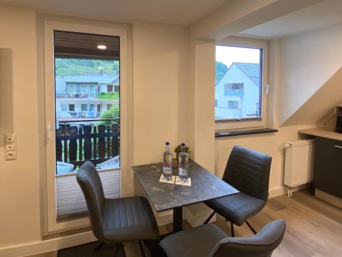 una sala da pranzo con tavolo, sedie e finestra di Haus am Iberg 4 a Willingen