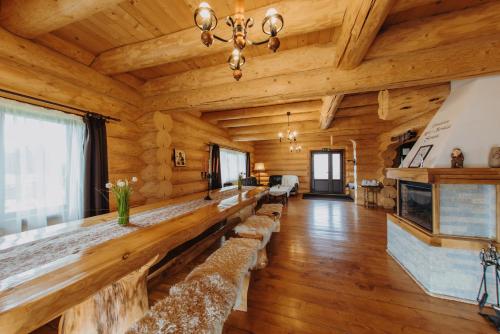 un ampio soggiorno con pareti in legno e pavimenti in parquet di Pensiunea Saranis a Beliş