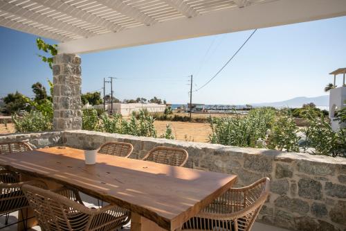 a wooden table and chairs on a stone wall at Cosmos Hotel in Plaka