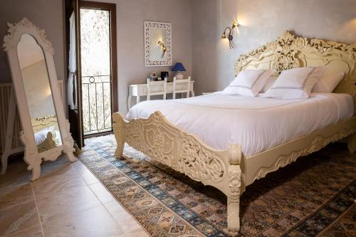 een slaapkamer met een groot bed met witte lakens bij Chambre d'Hôtes Au Jardin Des Saveurs in Cordes-sur-Ciel