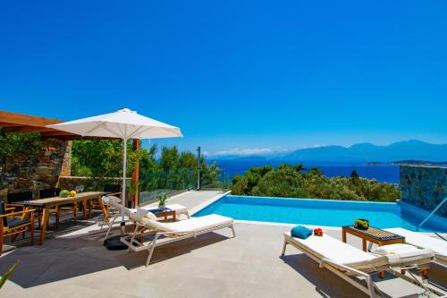 a villa with a swimming pool with a view of the ocean at Mirabella Hills in Agios Nikolaos