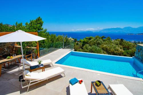 a villa with a swimming pool and a view of the ocean at Mirabella Hills in Agios Nikolaos