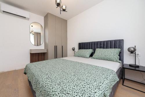 sypialnia z dużym łóżkiem i lustrem w obiekcie City Lux Apartment 2 - with garage and balcony w mieście Zadar