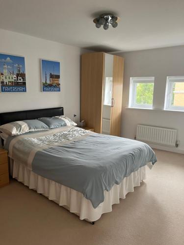 1 dormitorio con 1 cama grande y 2 ventanas en Hampton Vale, Peterborough Lakeside Large Double bedroom with own bathroom en Peterborough