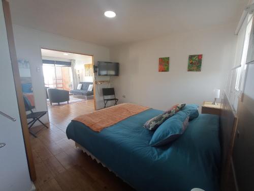 1 dormitorio con 1 cama azul y sala de estar en Loft Tongoy 1 frente al mar, en Coquimbo