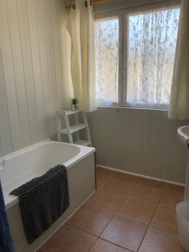 a bathroom with a bath tub and a window at La Forestine in Bergerac
