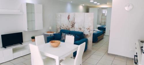 a living room with a blue couch and a white table at Nino's Apartments in Giardini Naxos