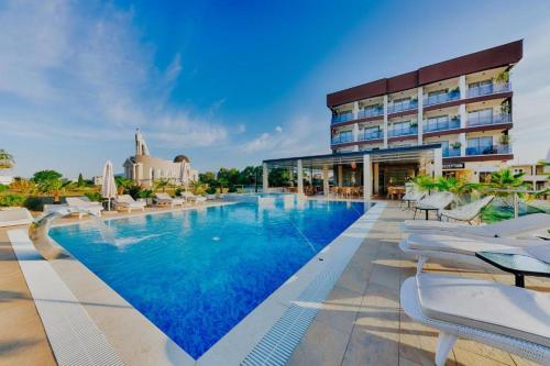 een zwembad in een hotel met stoelen en een gebouw bij Hotel Lion in Ulcinj