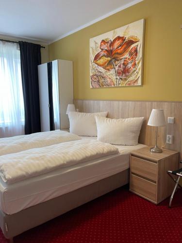 a large bed in a hotel room with a lamp at Palm Premium Hotel & Apartments in Düsseldorf