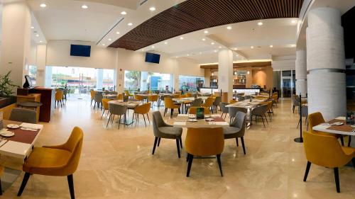 a dining room with tables and chairs and tablesktop at Holiday Inn Tuxpan - Convention Center by IHG in Tuxpan de Rodríguez Cano