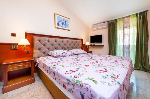 a bedroom with a bed and a table and a television at Nonna Marija 1 in Rovinj