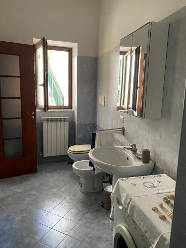 a bathroom with two toilets and a sink and a mirror at ALMA FLEGREA in Bacoli