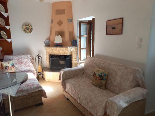a living room with a couch and a fireplace at ΠΗΛΙΟ- ΤΟ ΕΞΟΧΙΚΟ ΤΗΣ ΑΝΝΑΣ- ΑΦΗΣΣΟΣ in Afissos