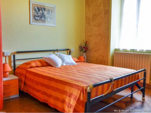 a bedroom with a bed with an orange blanket at Casa Vacanze Nonna Nella in Villafranca in Lunigiana