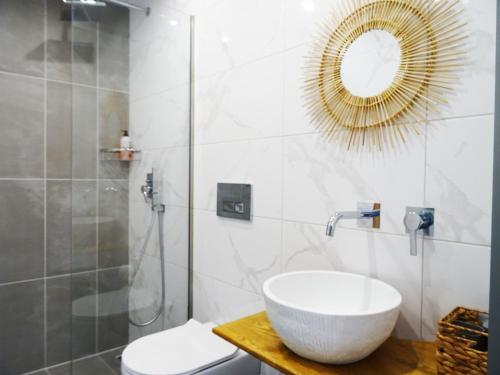 uma casa de banho com um lavatório, um chuveiro e um espelho. em Callas Residence em Triánta