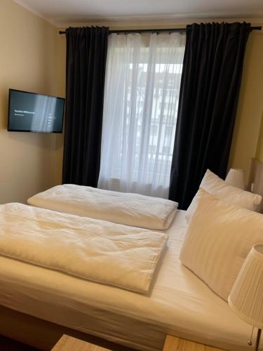 two beds in a hotel room with a window at Palm Premium Hotel & Apartments in Düsseldorf