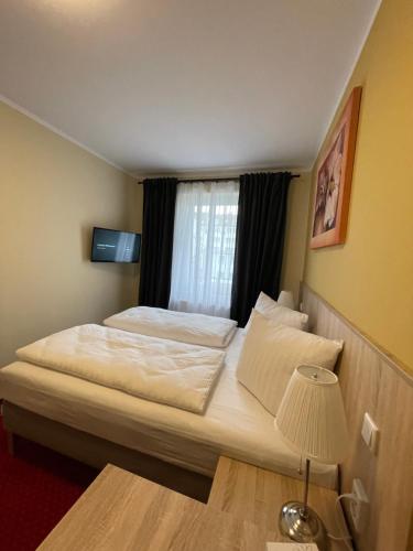 a bedroom with a large bed with a window at Palm Premium Hotel & Apartments in Düsseldorf