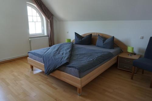 a bedroom with a bed with blue pillows and a window at Villa Ostgardie in Schleswig