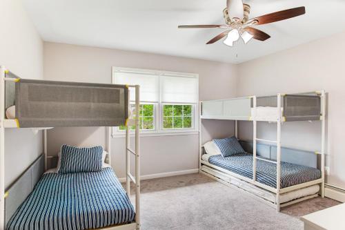 a bedroom with two bunk beds and a ceiling fan at Pine Whiff Gardens in Annapolis