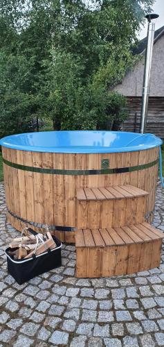 a large wooden tub with a blue top on a patio at Podlaski Zakątek in Bereżyszcze