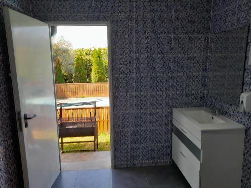 łazienka z drzwiami otwierającymi się na patio z umywalką w obiekcie Refúgio Singelo w mieście Espinho