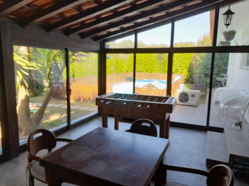 a kitchen with a table and chairs and windows at Refúgio Singelo in Espinho