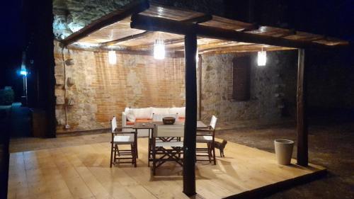 a table and chairs in a room with a brick wall at Affitti Brevi Toscana - Ospitalità in Campagna in Talamone