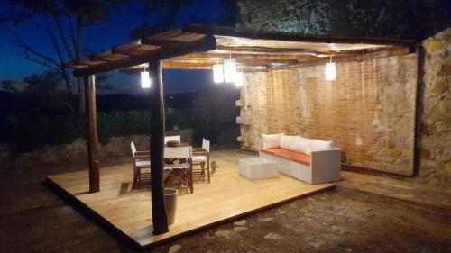 a wooden deck with a table and a couch and a table and chairs at Affitti Brevi Toscana - Ospitalità in Campagna in Talamone