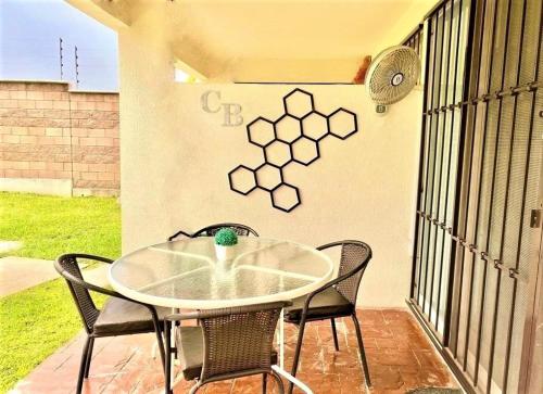 a table and chairs on a patio with a wall at CASABONITA fte alberca, AirAc in Alpuyeca