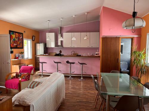 コスタ・ダ・カパリカにあるA Perfect Vacation - Beach and Cityのリビングルーム(テーブル付)、ピンクのキッチンが備わります。