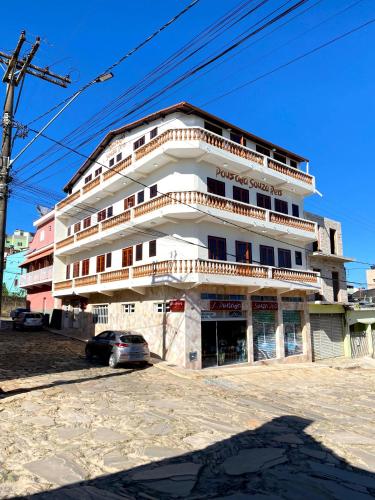 un edificio con un'auto parcheggiata di fronte di Pousada Souza Reis a São Thomé das Letras