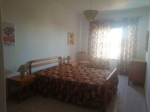 un dormitorio con una cama y una ventana en T1 em Alvor, en Alvor