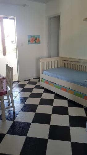 a bedroom with a bed and a checkered floor at Di Raffaele Bombinhas in Bombinhas