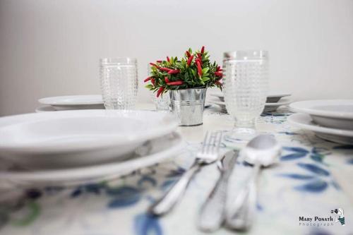 a table with plates and utensils on a table at Di Raffaele Bombinhas in Bombinhas