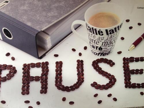 a word made out of coffee beans next to a cup of coffee at Hotel Carbayon in Oviedo