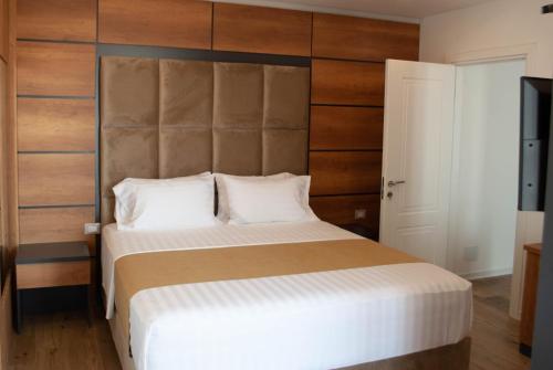 a bedroom with a large bed with a wooden headboard at Hilal Palace - Halal in Golem