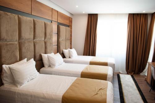 Cette chambre comprend 2 lits et une fenêtre. dans l'établissement Hilal Palace - Halal, à Golem