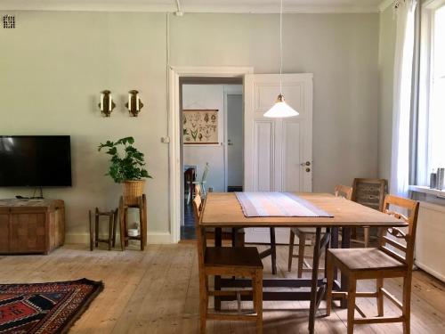 een eetkamer met een tafel en stoelen en een televisie bij Borgviks herrgårdsflygel in Borgvik