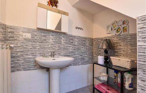 een badkamer met een wastafel, een spiegel en een plank bij 1 Bedroom Awesome Home In Piedimonte Etneo in Piedimonte Etneo