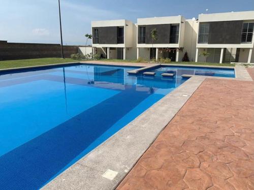 una piscina frente a un edificio en "Casa Bonita" fte alberca, AirAc en Alpuyeca