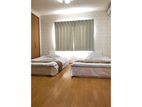 a bedroom with two beds and a window at Shinshuku - Vacation STAY 73572v in Kyoto